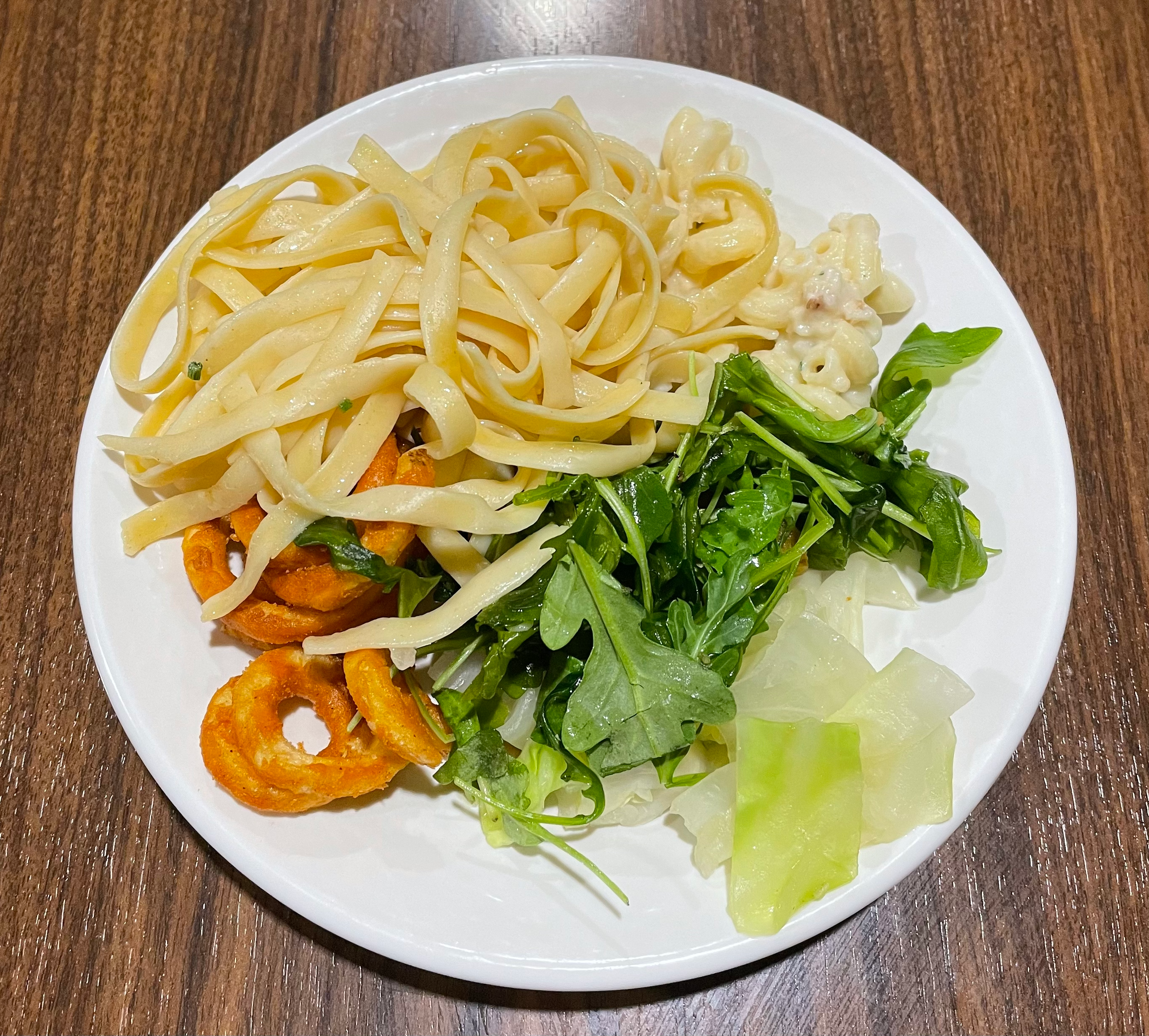 Shrimp scampi with pasta, white truffle macaroni, curly fries, butter cabbage, and arugula salad